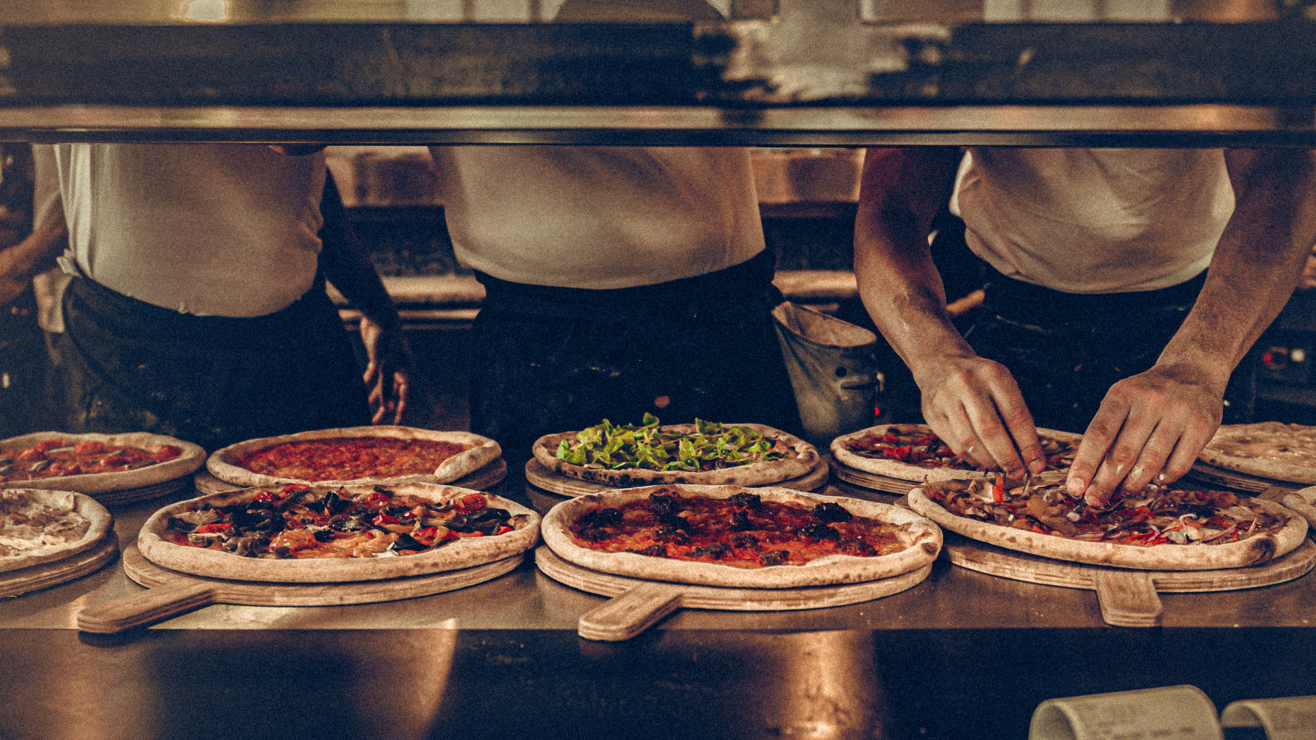 des cuisiniers qui font des pizzas