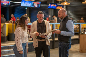 3 personnes discutant debout