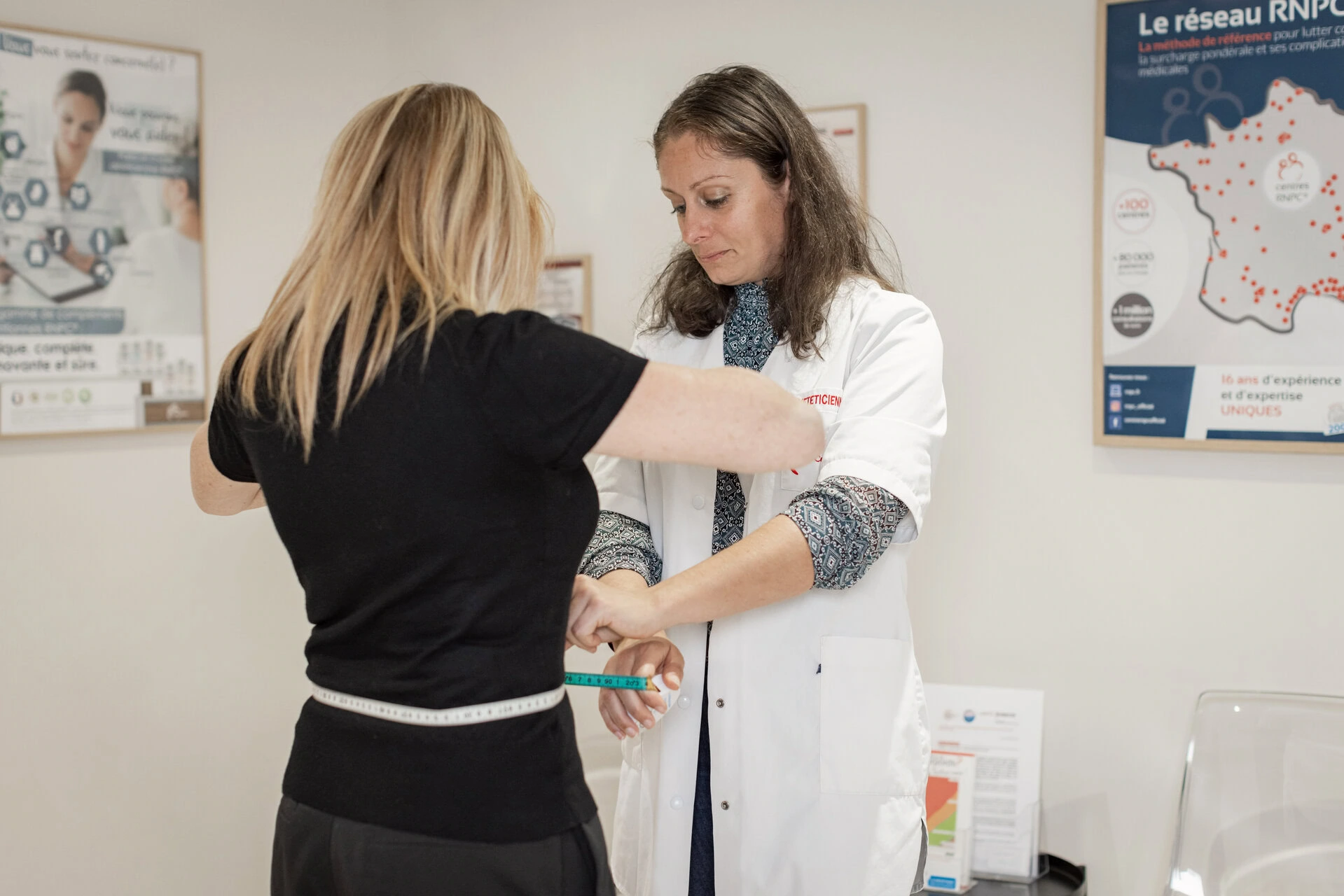 2 femmes dont une diététicienne prenant ses mesures